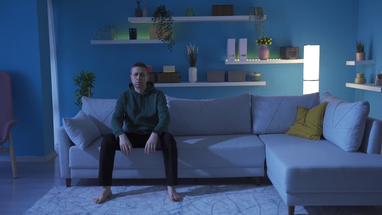 hombre maduro infeliz y deprimido solo en una casa oscura.