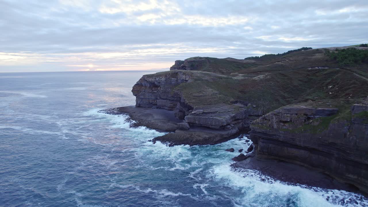 Drone footage of Isla island's rocky and broken edge and the blue Cantabrian sea is flowing in front of it