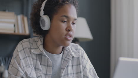 teenager listening to music and studying online