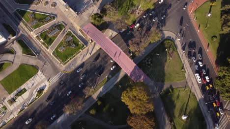 Toma-Aérea-Circular-Del-Tráfico-En-La-Carretera-Y-El-Puente-Rojo-De-La-Facultad-De-Derecho-Durante-La-Puesta-De-Sol