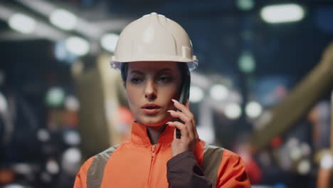 retrato ingeniero de fábrica hablando por teléfono móvil en la producción. mujer artesano llamada