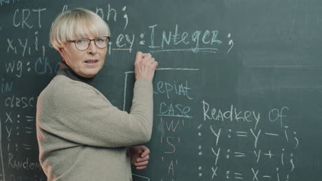 teacher explaining programming concepts on a chalkboard