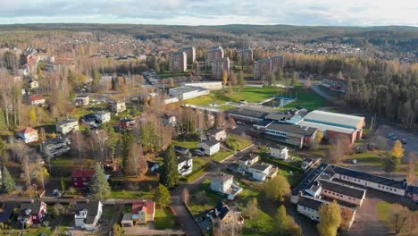 drone footage flying over a residential area and a school in a small town with a large swimming pool and more houses in the background