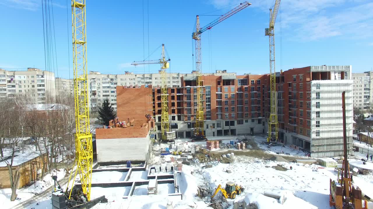 Aerial view of crane and building construction site in winter season
