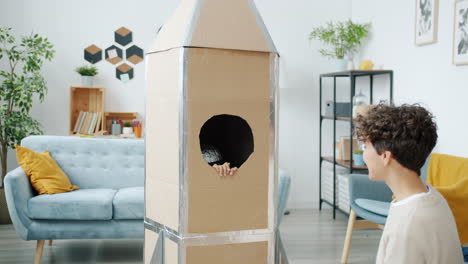 kids play in cardboard rocket ship