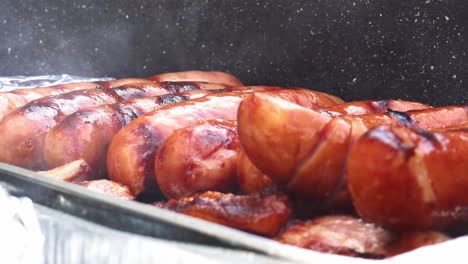 pork sausages on the grill with smoke in the foreground