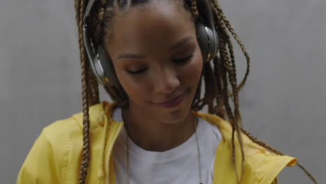 beautiful young mixed race woman listening to music wearing headphones smiling happy enjoying carefree lifestyle close up