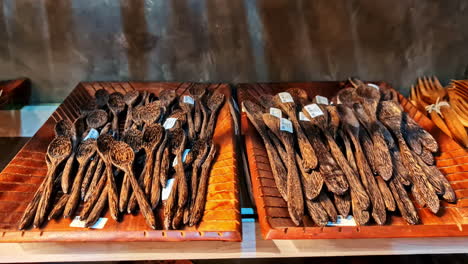 carved wooden spoons neatly arranged on trays at local craft market in sri lanka