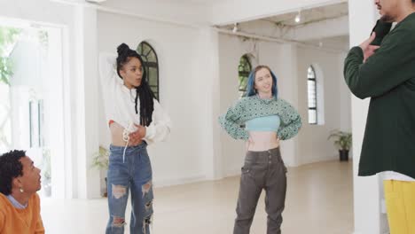 happy diverse male and female dancers discussing in dance studio, slow motion