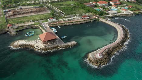 Flotando-Sobre-Las-Profundas-Aguas-Azules-Que-Revelan-Un-Maravilloso-Rompeolas-Acompañado-De-Un-Faro-Con-Una-Vista-Espectacular