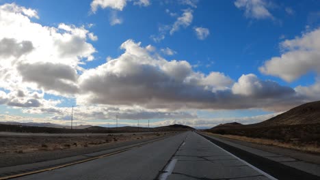 driving along a highway through the mojave desert on a beautiful day - point of view