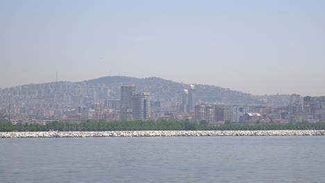 a city skyline on a clear day with water in the foreground