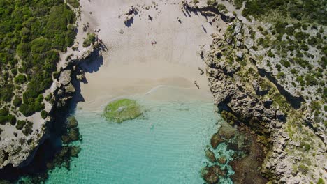 Aerial-view-over-people-in-Salmon-Bay,-Rottnest-Island,-Australia--ascending-birds-eye,-drone-shot