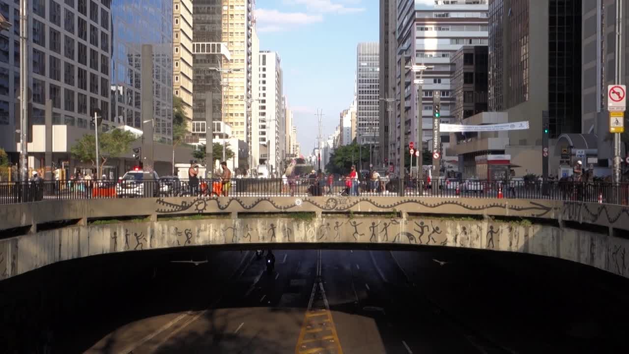 usual movement of people and cars at Paulista Avenue, the most famous in the city. Police on horse cross over the viaduct