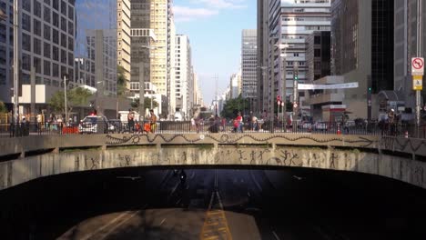 usual movement of people and cars at paulista avenue, the most famous in the city. police on horse cross over the viaduct
