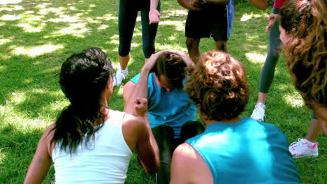 grupo de fitness animando a un hombre haciendo abdominales