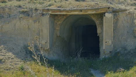 a shot of a entrance of a abandoned house carved into the rock