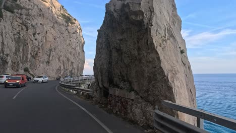 driving along a cliffside road by the sea