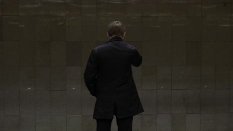 person standing backwards in subway station