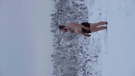 un hombre se está preparando para ejecutar un handstand en la nieve profunda - tiro vertical