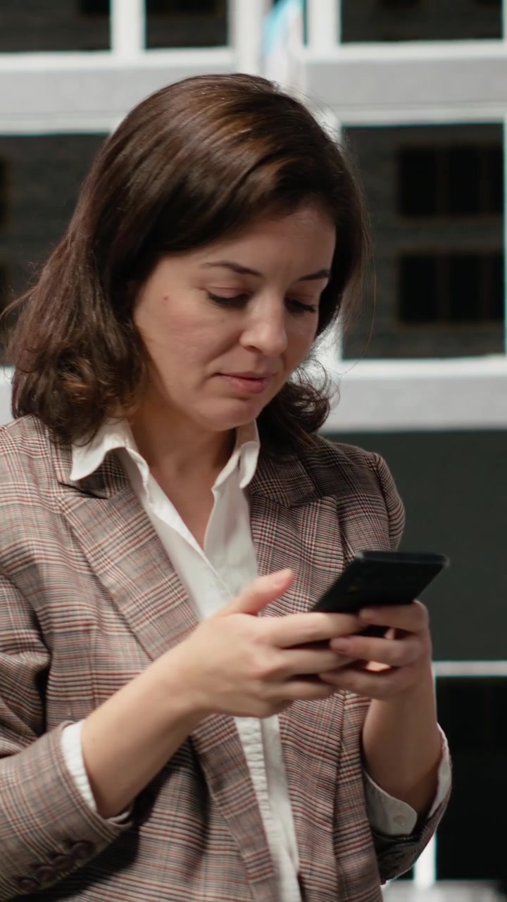 Video verticale: Primo piano di un professionista che controlla lo smartphone in una strada del centro.