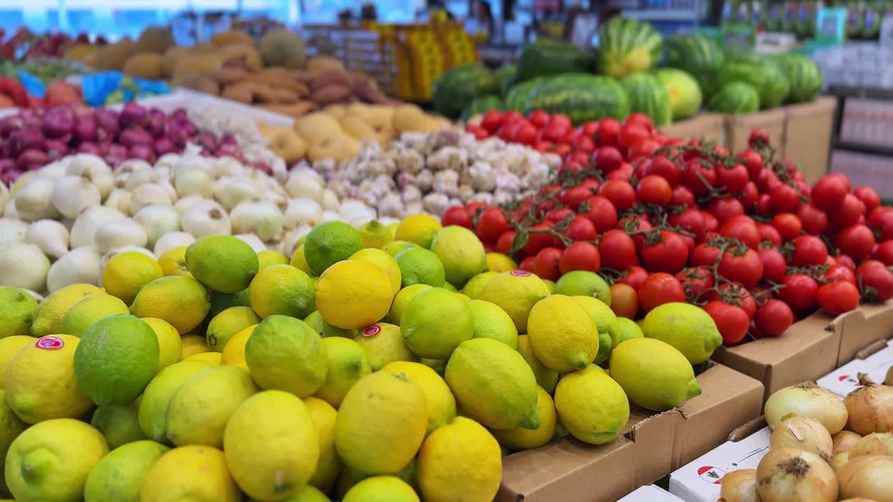 High-resolution 4K footage of vibrant fruits and vegetables including lemons, tomatoes, onions, and garlic at a bustling market. Ideal for food, retail, grocery, and nutrition content.