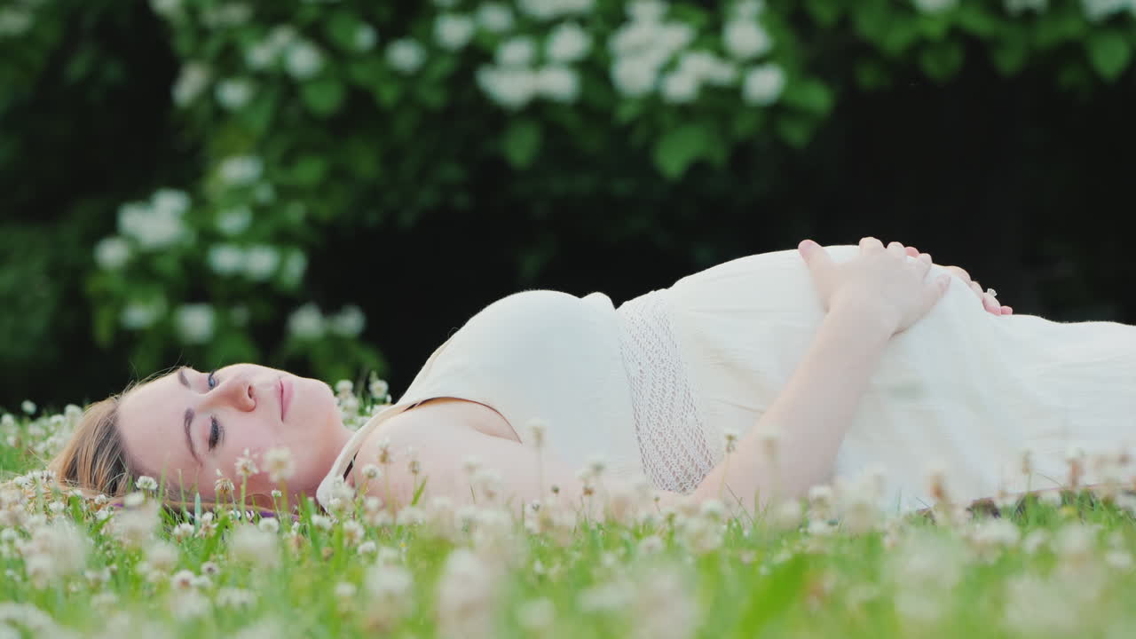 젊은 임산부는 잔디 꿈에 누워