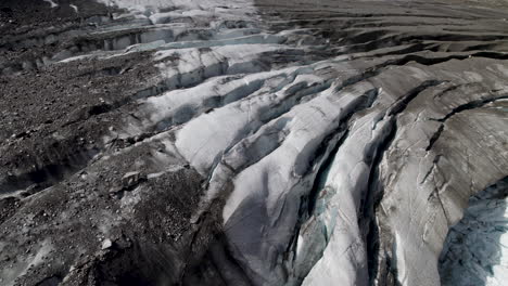 Debris-covered-Pasterze-glacier-surface-in-the-Eastern-Alps-melting-due-to-climate-change-and-global-warming,-Retreating-glacier,-Austria,-Aerial-Closeup