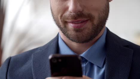 hombre de negocios atractivo enviando mensajes de texto por teléfono celular. hombre sonriente enviando mensajes de texto por teléfono inteligente.