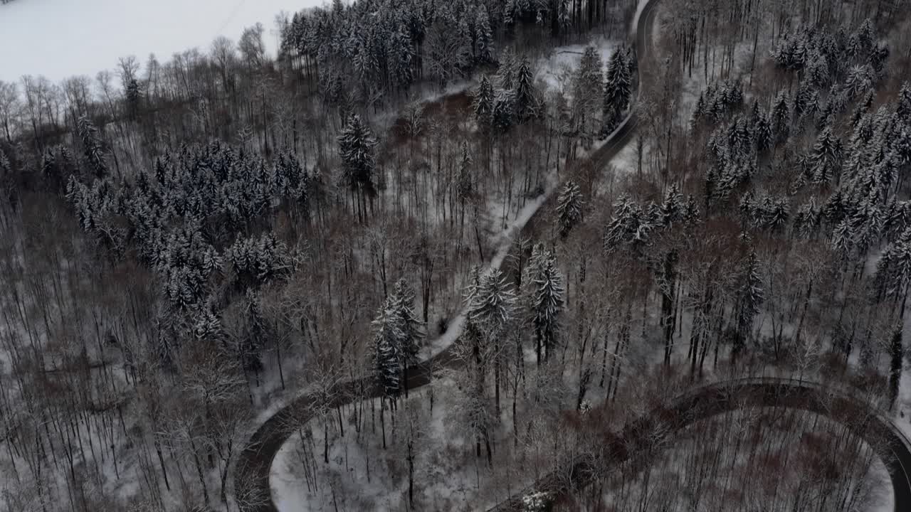 Ripresa dal basso con drone di una strada tortuosa con la meta di viaggio "Abbazia di Schäftlarn" durante la splendida stagione invernale.