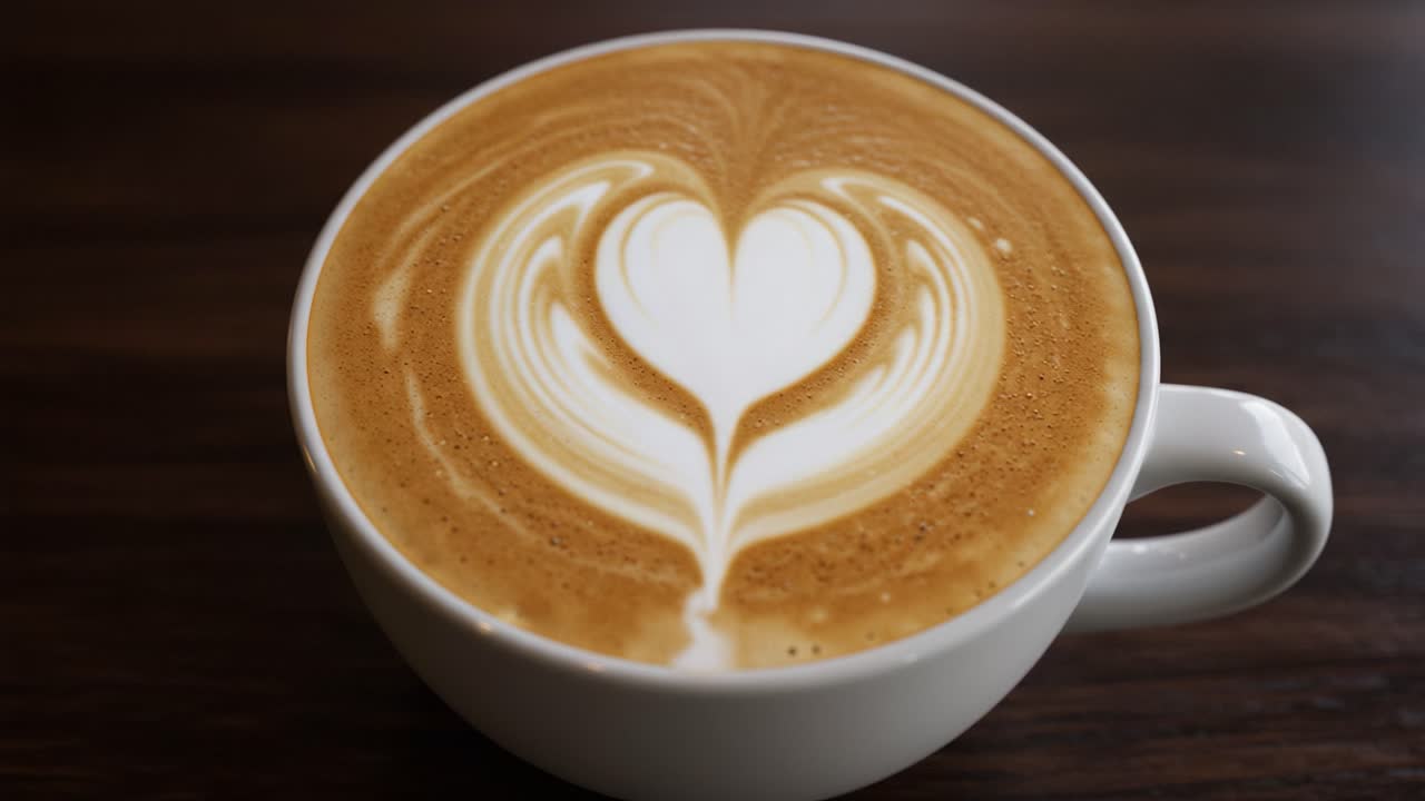 latte,coffee,art,heart,design,cappuccino,creamer,milk,foam,beverage,caffeine,espresso,barista,brew,cup,white,smoothing,texture,pattern,warm,drink,taste,aroma,bistro,comfort,morning,cafe,warmth,refreshing,artistry,rich,indulgence,presentation,table,coffee shop,enjoy,sip,moment,experience,visual