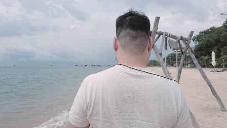 여름 방학 휴가 시간에 하얀 모래 해변을 걷는 동안 아시아 남자