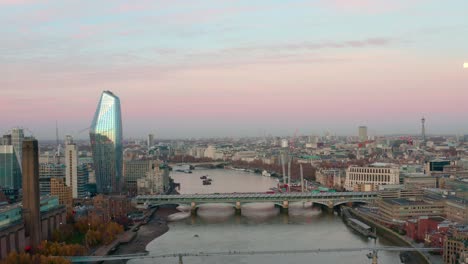 Dolly-forward-aerial-of-millennium-and-Blackfriars-bridge-over-Thames-river-early-morning-sunrise