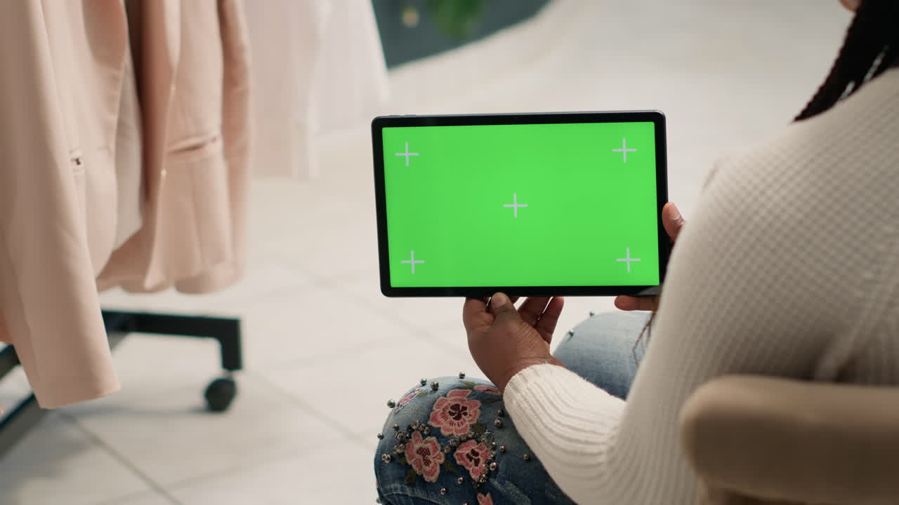 Woman with green screen in clothing shop