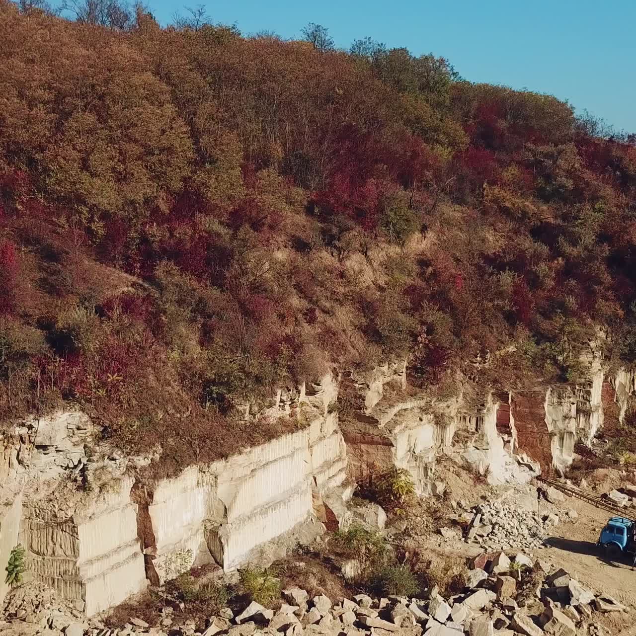 view of a large sand quarry with stones and forest. Professional equipment works for the extraction of sand. Camera motion left