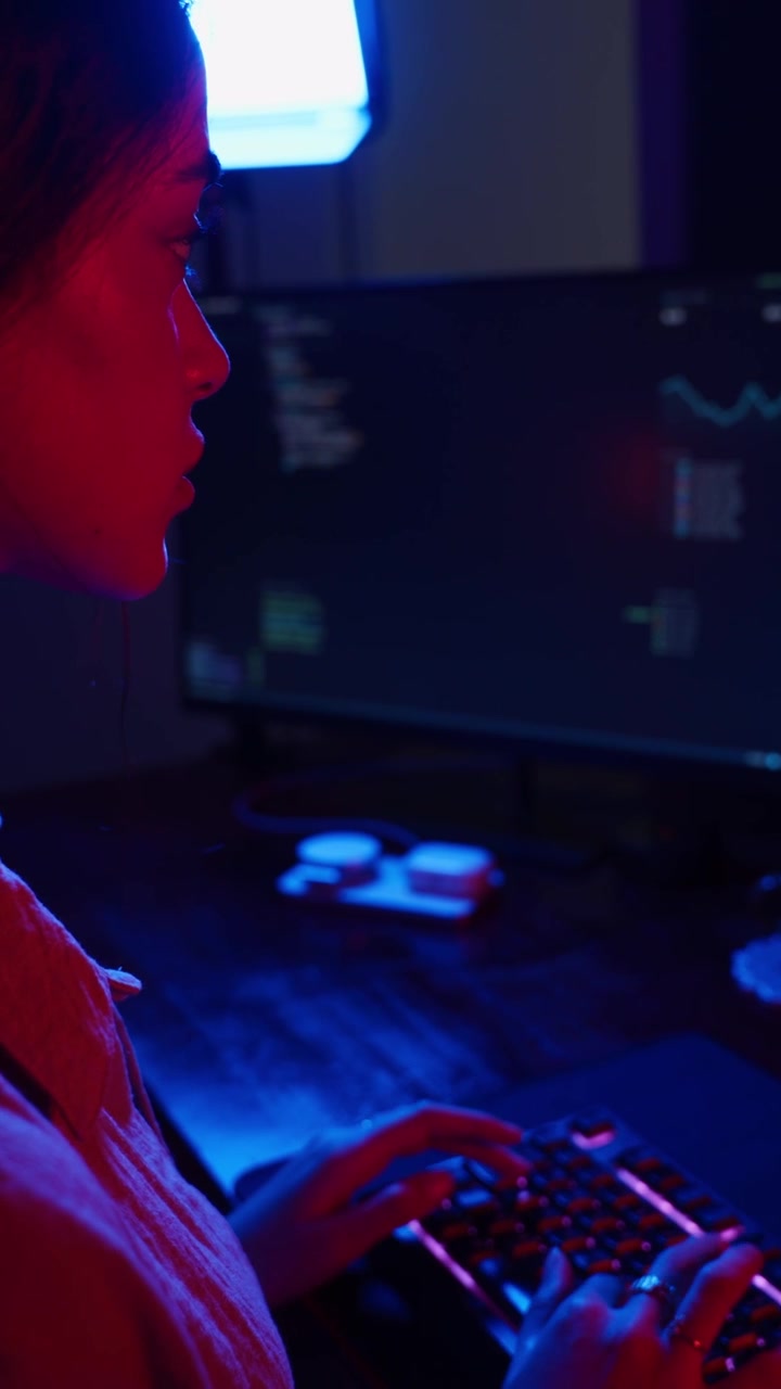 Young Woman Coding on Computer in Dark Room