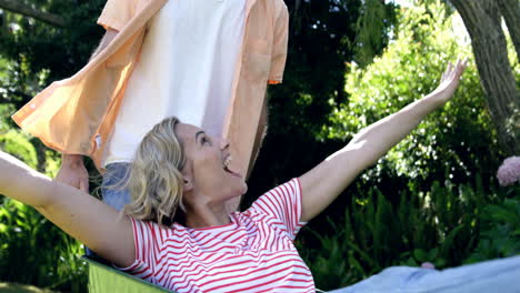 happy couple playing with a wheelbarrow in the garden