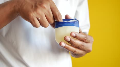 close up of man hand using petroleum jelly