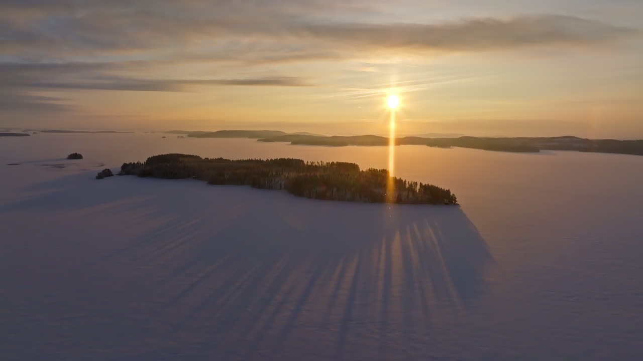 Drone circling a island in the arctic lakelands of Finland, moody, winter sunrise
