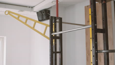 a sportive young man does pull ups in the gym