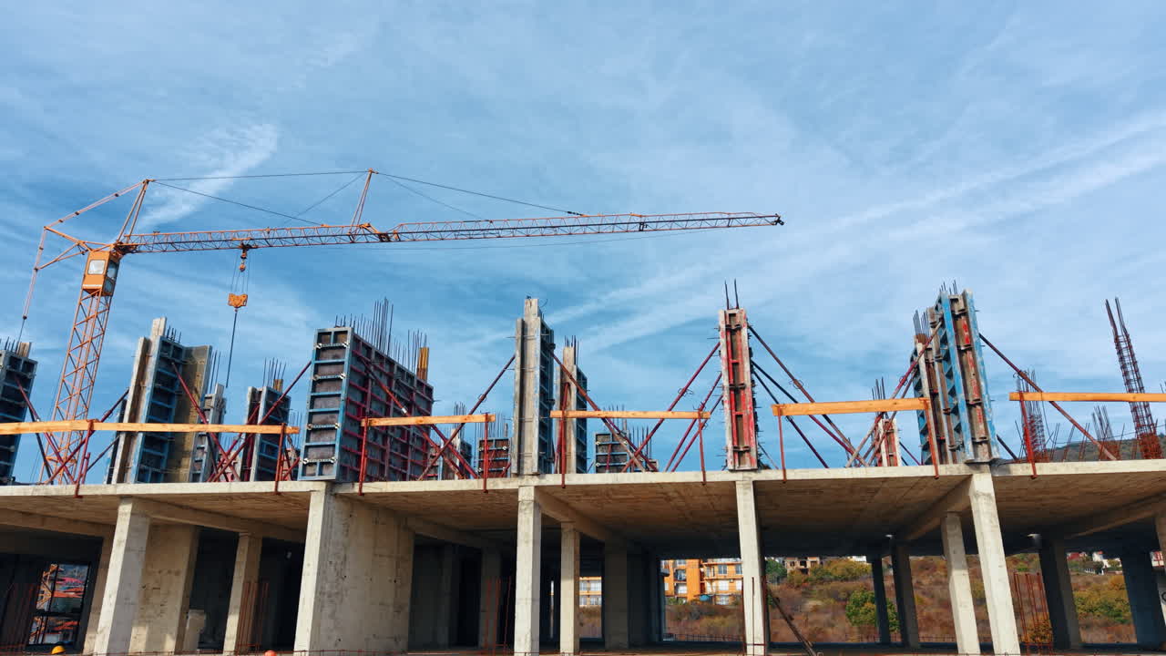 Construction frame towering over the building frame. Low angle view. Metal rebars are installed on the roof