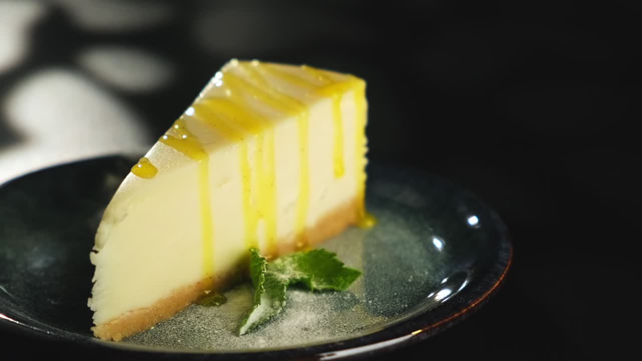 A piece of lemon sweet dessert on a plate on a black background.
