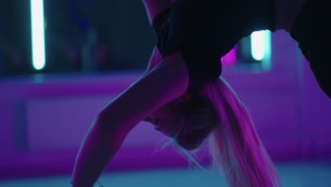 graceful woman is hanging in hammock in gymnastic hall training and dancing physical exercise