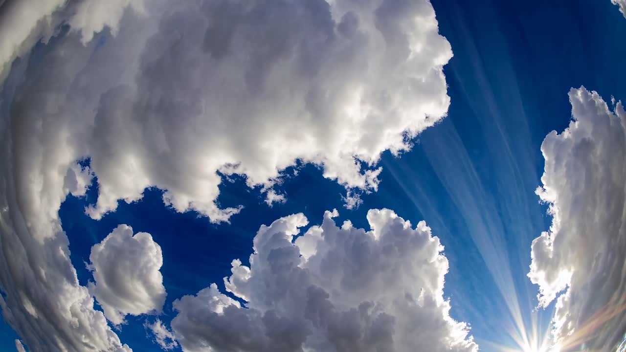 Et fiskeøyeobjektiv fanger dramatiske skyer mot en dyp blå himmel, og skaper en dynamisk og engasjerende video
