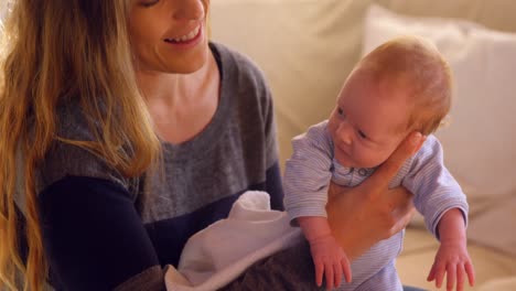 mother comforting her baby in living room 4k