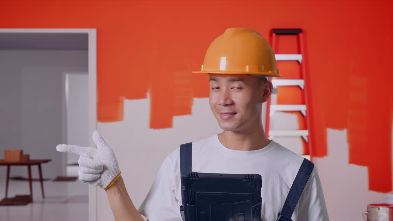 Smilende entreprenør som peker med nettbrett.