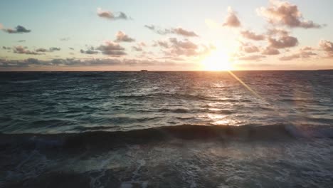 Drone-Shot-flying-over-the-ocean-towards-a-beautiful-colorful-Hawaiian-sunrise-on-the-horizon