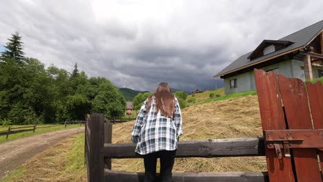 young woman looking at the mountains and a cabin