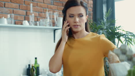 Mujer-Desempacando-Bolsa-De-Compras-En-La-Cocina.-Chica-Preocupada-Hablando-Por-Teléfono-En-Casa.