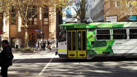 un tranvía se mueve a través de una concurrida intersección de melbourne